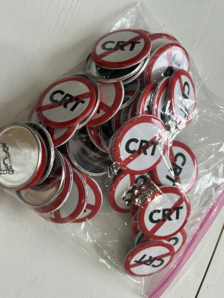 Các bậc cha mẹ lo ngại về thuyết chủng tộc trọng yếu mang về nhà những huy hiệu này từ một khóa đào tạo của các nhà hoạt động hội đồng trường vào hôm 19/01/2022 tại Sarasota, Florida. (Ảnh: Đăng dưới sự cho phép của Alexis Spiegelman)