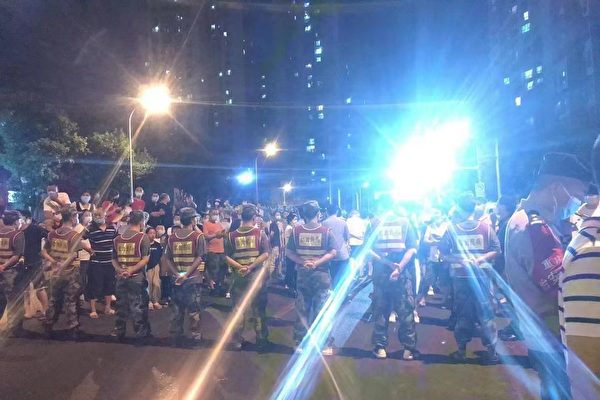 Hôm 27/08, cư dân của Phường Liên Phường, quận Sa Bình Bá, thành phố Trùng Khánh, biểu tình phản đối lệnh phong tỏa kéo dài 10 ngày. Lực lượng dân quân Trùng Khánh dàn hàng ngang đối đầu với người biểu tình. (Ảnh chụp màn hình từ ấn bản Hoa ngữ của The Epoch Times)