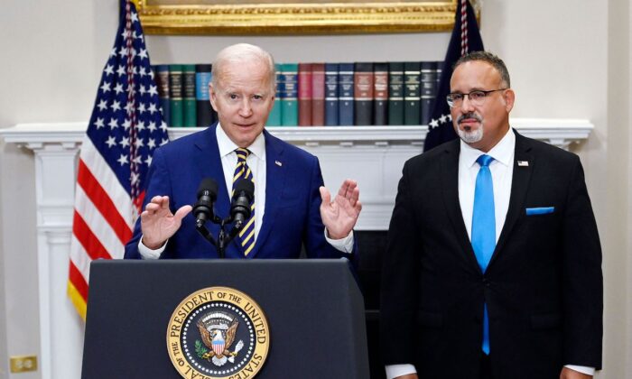 Tổng thống Joe Biden công bố cứu trợ khoản vay sinh viên với Bộ trưởng Giáo dục Miguel Cardona (phải) tại Tòa Bạch Ốc ở Hoa Thịnh Đốn vào ngày 24/08/2022. (Ảnh: Olivier Douliery/AFP via Getty Images)
