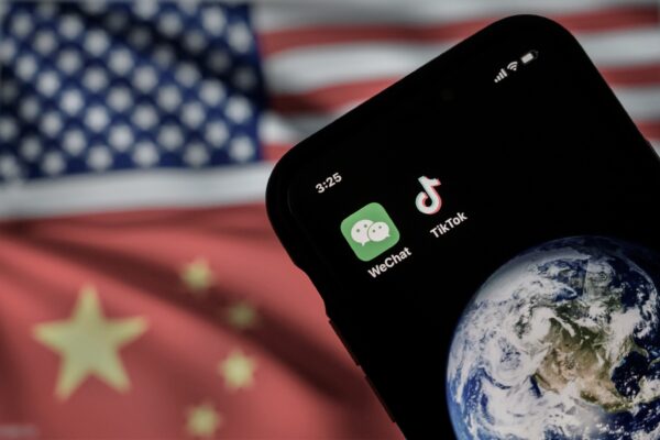 Một chiếc điện thoại di động đang hiển thị logo của các ứng dụng Trung Quốc WeChat và TikTok trước màn hình hiển thị các quốc kỳ của Hoa Kỳ và Trung Quốc trên một trang Internet, ở Bắc Kinh, vào ngày 22/09/2020. (Ảnh: Kevin Frayer/Getty Images)