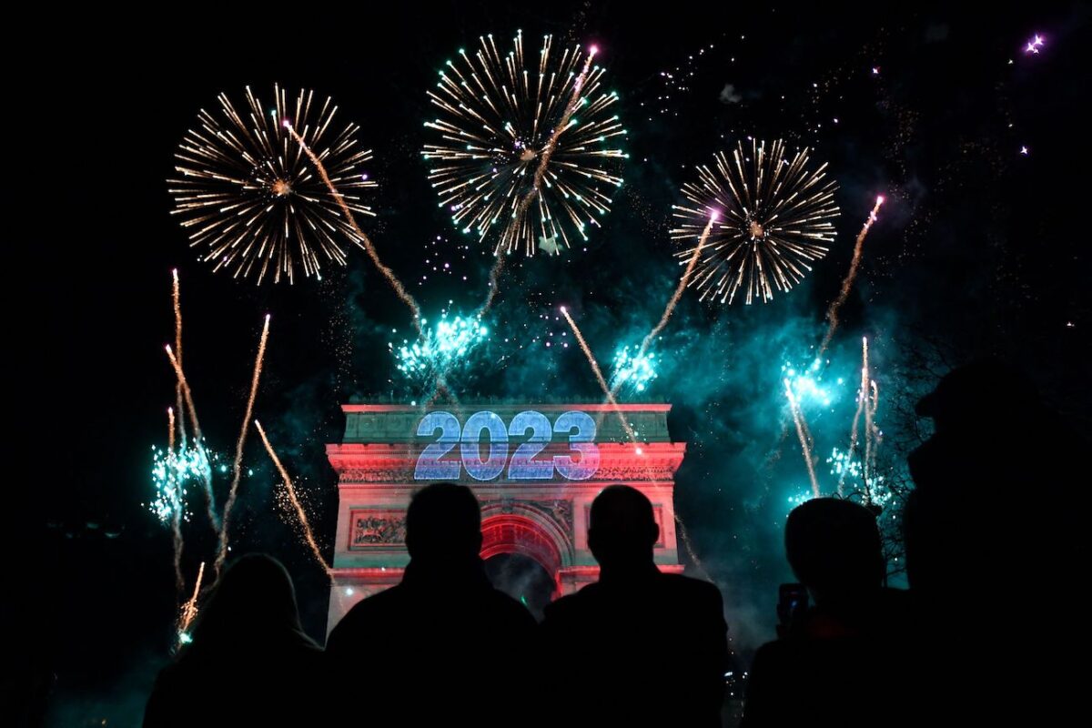 Mọi người tụ tập trên đại lộ Champs-Elysees khi chờ bắn pháo hoa đêm giao thừa ở Paris hôm 31/12/2022. (Ảnh: Julien de Rosa/AFP qua Getty Images)