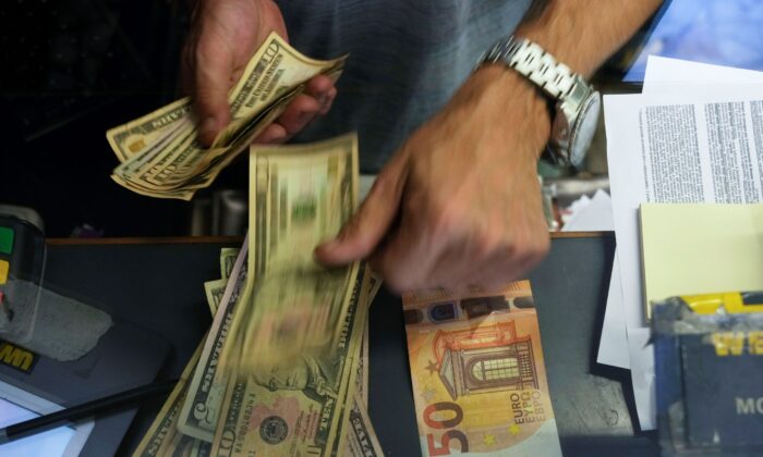 Một nhân viên thu ngân đổi một tờ 50 Euro sang USD tại một quầy đổi tiền ở Rome, Ý, hôm 13/07/2022. (Ảnh: Gregorio Borgia/AP)