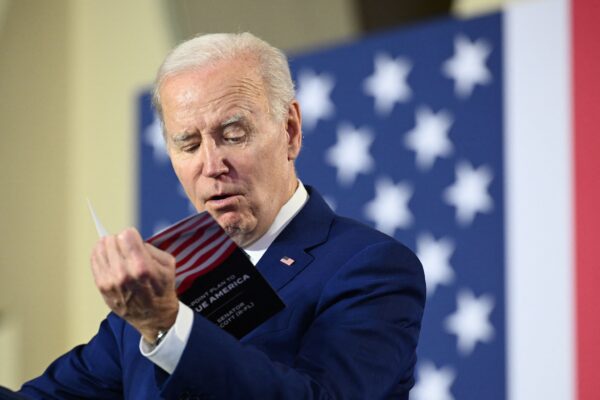 Tổng thống Joe Biden đọc cuốn tài liệu của Thượng nghị sĩ Rick Scott (Cộng Hòa-Florida) trong khi đưa ra nhận xét về kế hoạch bảo vệ và củng cố An sinh xã hội và Medicare, cũng như cắt giảm chi phí chăm sóc sức khỏe, tại Đại học Tampa ở Tampa, Florida, hôm 09/02/2023. (Ảnh: Mandel Ngan/AFP qua Getty Images)