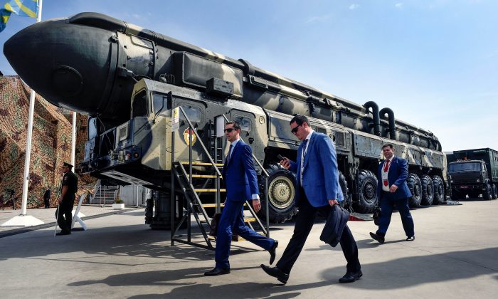 Các chuyên gia quân sự đi ngang qua một hỏa tiễn đạn đạo xuyên lục địa (ICBM) Topol của Nga tại khu vực triển lãm ở Công viên Ái Quốc Kubinka bên ngoài Moscow ngày 22/08/2017. (Ảnh: Alexander Nemenov/AFP/Getty Images)