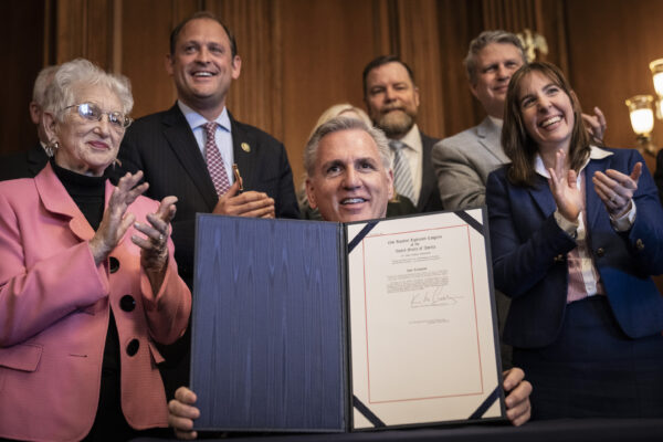 Chủ tịch Hạ viện Kevin McCarthy (Cộng Hòa-California), với Thống đốc Ngân khố Tiểu bang Kentucky Allison Ball đứng phía sau (ngoài cùng bên phải), ký một nghị quyết ngăn chặn quy tắc của chính phủ Tổng thống Biden khuyến khích các nhà quản lý hưu trí xem xét các yếu tố về môi trường, xã hội, và quản trị doanh nghiệp (ESG) khi đưa ra quyết định đầu tư, trong buổi lễ ký dự luật tại Điện Capitol Hoa Kỳ ở Hoa Thịnh Đốn hôm 09/03/2023. (Ảnh: Drew Angerer/Getty Images)