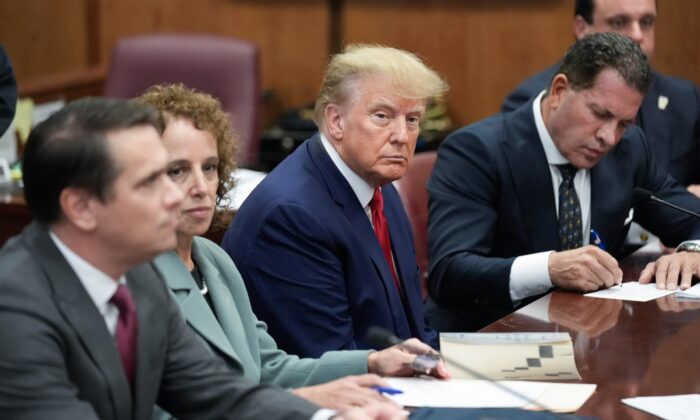 Cựu Tổng thống Donald Trump ngồi tại bàn bào chữa với đội luật sư biện hộ của ông tại tòa án Manhattan, hôm thứ Ba, 04/04/2023, tại New York. Ông Trump được sắp xếp trình diện tại phòng xử án ở Thành phố New York với các cáo buộc liên quan đến việc làm sai lệch các hồ sơ kinh doanh trong một cuộc điều tra về tiền bịt miệng. Ông là tổng thống đầu tiên từng bị buộc tội. (Ảnh: AP Photo/Seth Wenig)