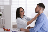Nữ bác sĩ kiểm tra tuyến giáp của một bệnh nhân tại bệnh viện. (Ảnh: Shutterstock)