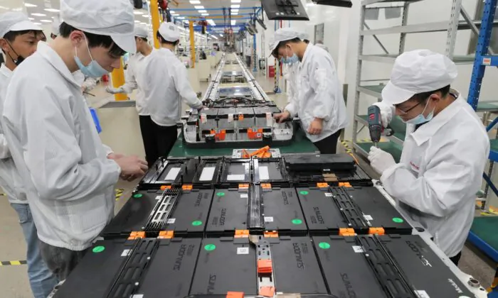Các công nhân nhà máy tại Công ty TNHH Pin Xe Điện Hân Vượng Đạt (Xinwangda), nơi sản xuất pin lithium cho xe hơi điện và các mục đích sử dụng khác, ở Nam Kinh thuộc tỉnh Giang Tô phía đông Trung Quốc, vào ngày 12/03/2021. (Ảnh: STR/AFP qua Getty Images)