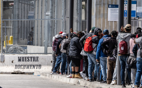 Người di cư xếp hàng chờ vào Hoa Kỳ từ Tijuana, Mexico, hôm 11/05/2023. (Ảnh: John Fredricks/The Epoch Times)