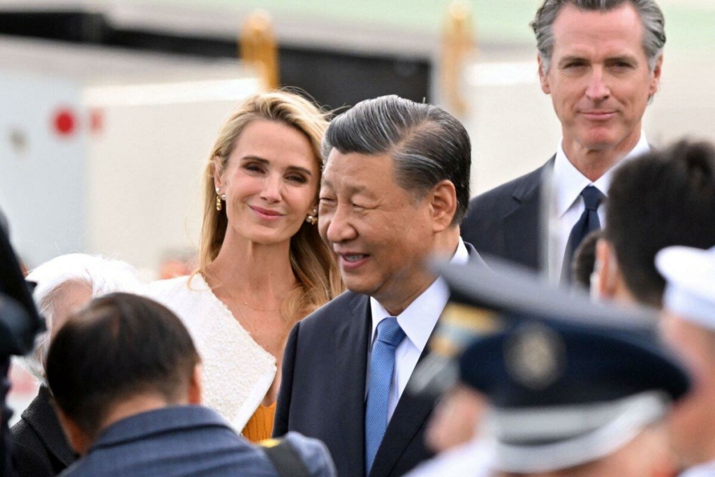 Thống đốc California Gavin Newsom (phải) và phu nhân Jennifer Siebel Newsom (trái) đứng nhìn khi lãnh đạo Trung Quốc Tập Cận Bình (giữa) đến phi trường quốc tế San Francisco để tham dự tuần lễ của các nhà lãnh đạo Diễn đàn Hợp tác Kinh tế Châu Á-Thái Bình Dương tại San Francisco, California, hôm 14/11/2023. (Ảnh: Frederic J. Brown/AFP qua Getty Images)