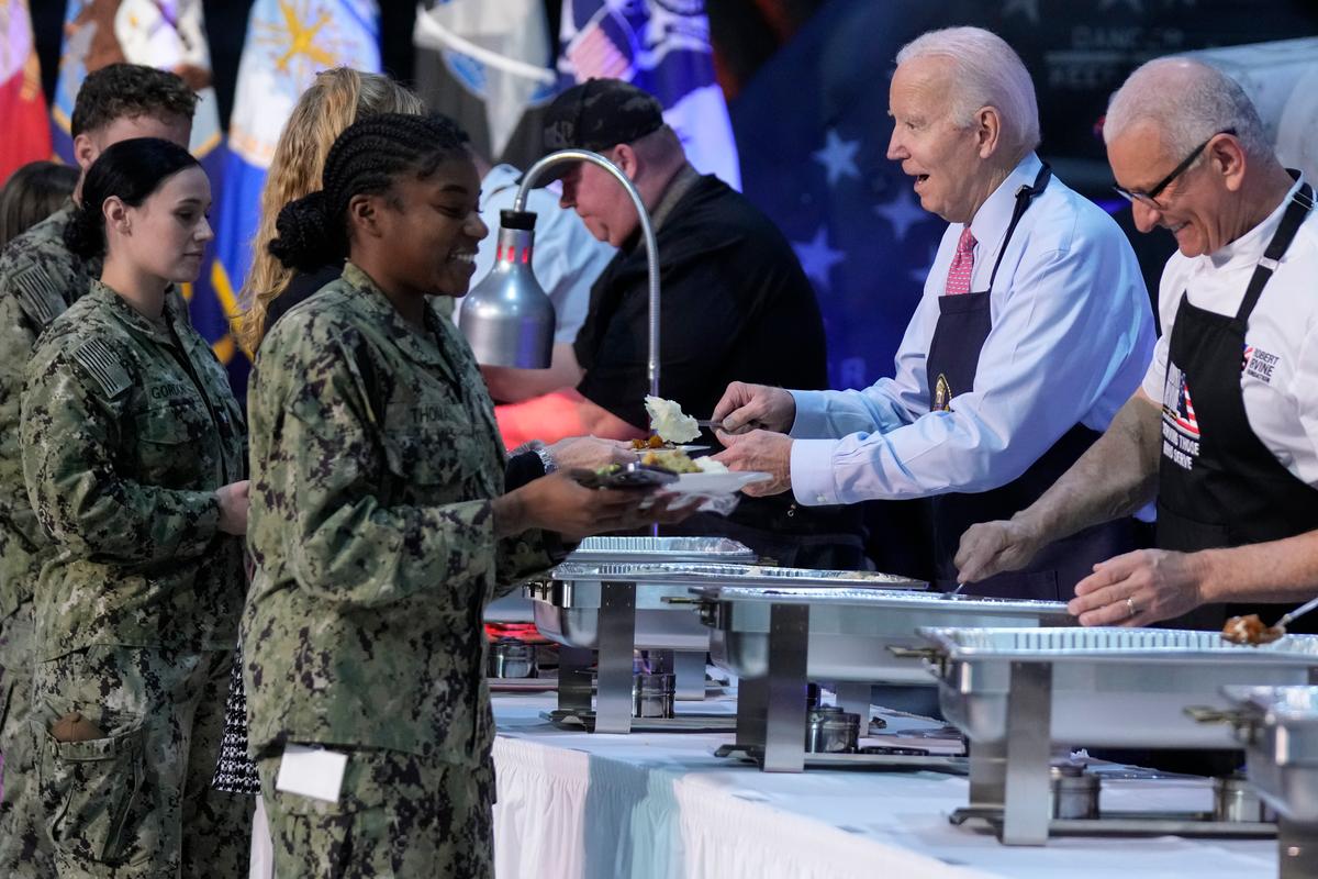 Tổng thống Joe Biden và đầu bếp Robert Irvine (bên phải) giúp phục vụ bữa ăn “Lễ Tạ Ơn với bằng hữu” cho các quân nhân và người thân của họ tại Trạm Hải quân Norfolk ở Norfolk, Virginia, hôm 19/11/2023. (Ảnh: Manuel Balce Ceneta/AP Photo)
