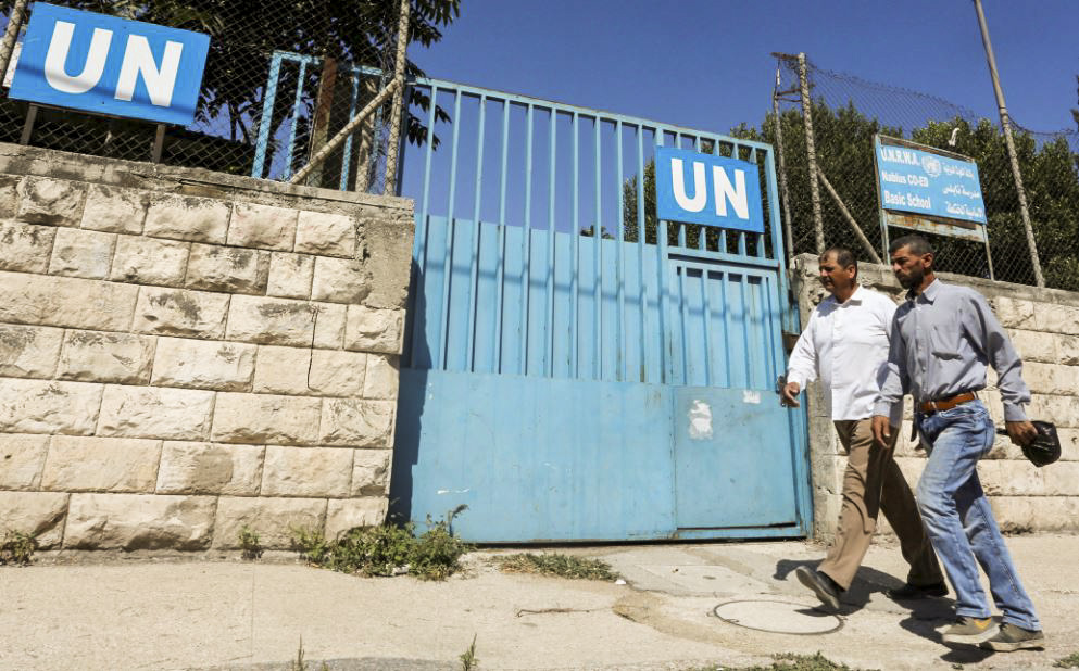 Người Palestine đi qua cổng một trường học do UNRWA điều hành ở Nablus ở Tây Ngạn, vào ngày 13/08/2018. (Ảnh: Abed Omar Qusini/Reuters)