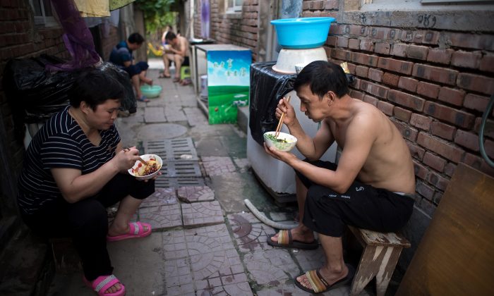 Người ăn tối trên đường phố trong một làng di cư ở vùng ngoại ô Bắc Kinh, ngày 17/08/2017. (Ảnh: Nicolas Asfouri/AFP/Getty Images)
