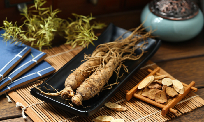Củ nhân sâm đặt trong chiếc đĩa đen trên bàn gỗ (Ảnh: shutterstock)