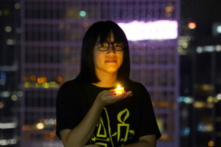Bà Chow Hang Tung, nữ phó chủ tịch Liên minh Hồng Kông Ủng hộ các Phong trào Dân chủ Yêu nước của Trung Quốc, tại Hồng Kông, vào ngày 03/06/2021, chụp ảnh cùng với một cây nến trước ngày tưởng niệm 32 năm vụ thảm sát những người biểu tình ủng hộ dân chủ tại Quảng trường Thiên An Môn, Bắc Kinh, vào năm 1989. (Ảnh: Lam Yik/Reuters)