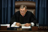 Chánh án John Roberts đọc câu hỏi của một thượng nghị sĩ trong thủ tục đàn hặc Tổng thống Donald Trump tại Thượng viện ở Tòa nhà Quốc hội Hoa Kỳ vào ngày 29/01/2020. (Ảnh: Truyền hình Thượng viện qua Getty Images)