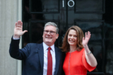 Thủ tướng sắp nhậm chức của Anh quốc Keir Starmer và phu nhân Victoria vẫy tay khi họ đứng trên bậc thềm số 10 Downing Street ở London, hôm 05/07/2024. (Ảnh: Justin Tallis/AFP qua Getty Images)