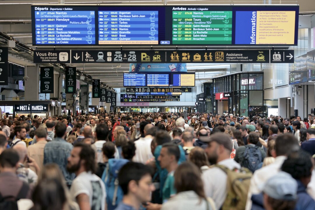 Hành khách tập trung quanh bảng điểm khởi hành và điểm đến tại nhà ga xe lửa Gare Montparnasse khi hệ thống đường sắt cao tốc của Pháp bị tấn công bởi các hành động ác ý làm gián đoạn hệ thống giao thông nhiều giờ trước lễ khai mạc Thế vận hội Olympic Paris năm 2024, tại Paris hôm 26/07/2024. (Ảnh: Thibaud Moritz/AFP qua Getty Images)