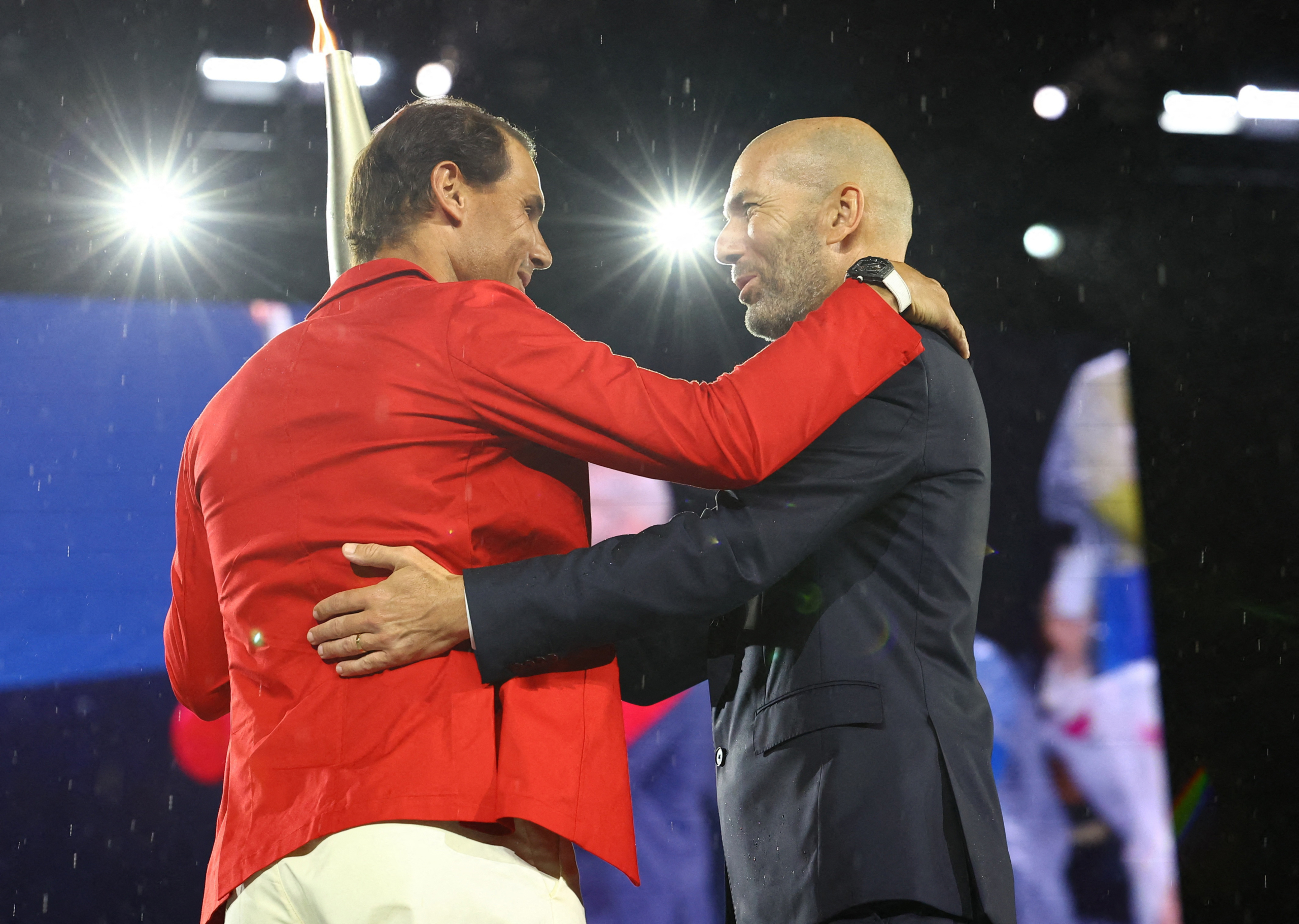 Người cầm đuốc Zinedine Zidane trao ngọn đuốc Thế vận hội cho tây vợt Tây Ban Nha Rafael Nadal trong Lễ khai mạc Thế vận hội 2024 tại Paris, hôm 26/07/2024. (Ảnh: Stephanie Lecocq /Pool/AFP qua Getty Images)